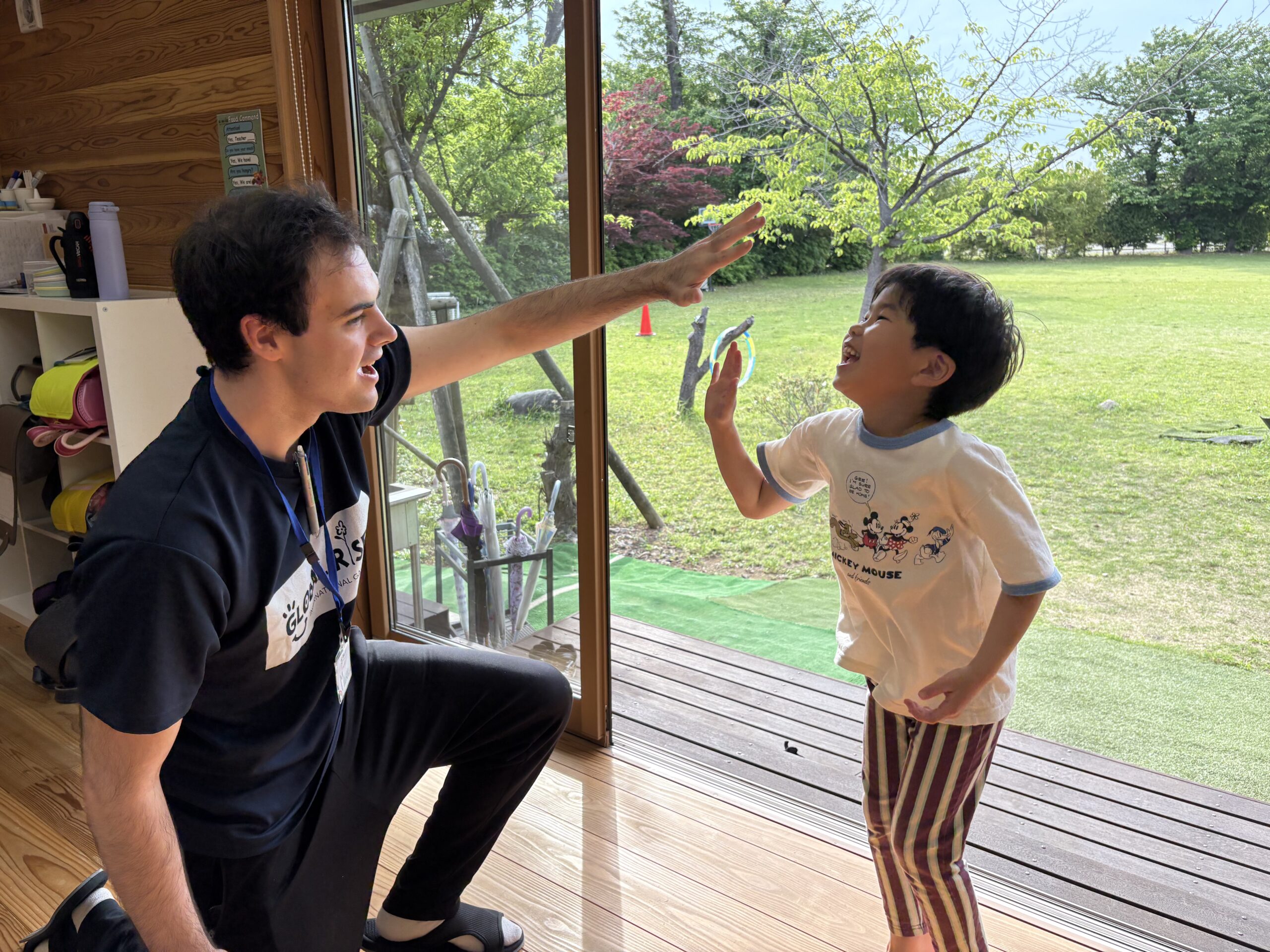 笑顔で先生とハイタッチする子ども