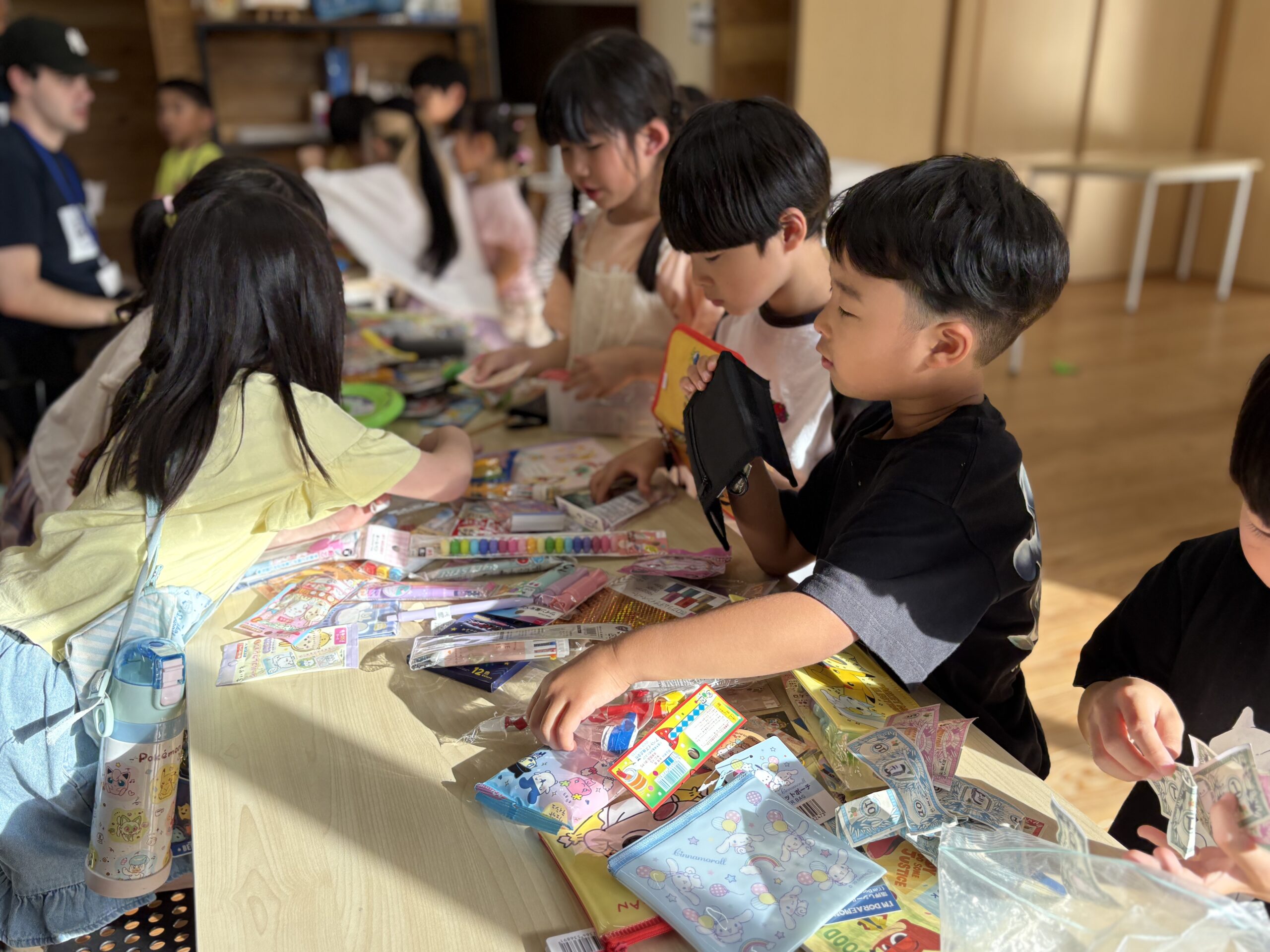机を囲んで制作に取り組む子どもたち